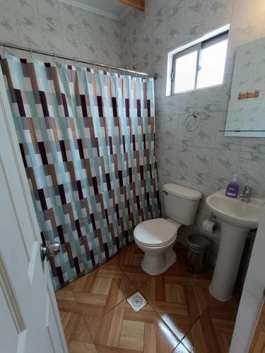 a bathroom with a toilet and a sink at Hostal Km Zero El Huertillo in San Pedro de Atacama