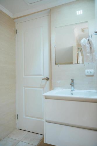 a white bathroom with a sink and a mirror at Gold coast elegance with private pool in Noord