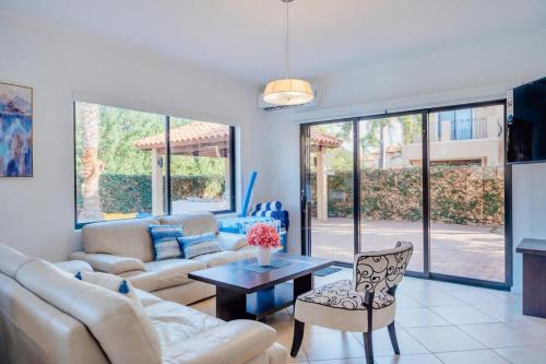 a living room with a couch and a table at Gold coast elegance with private pool in Noord