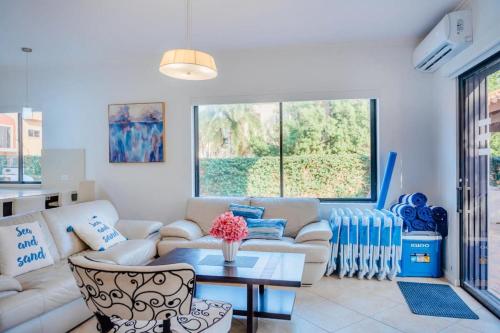 a living room with a couch and a table at Gold coast elegance with private pool in Noord