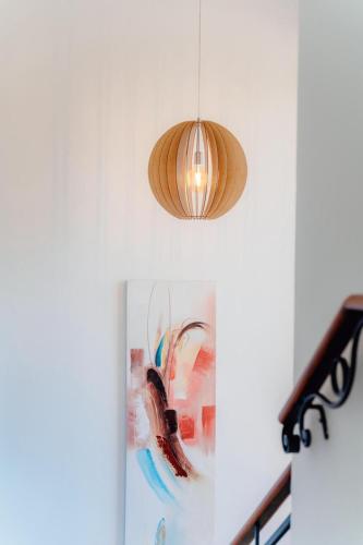 a pendant light hanging from a wall with a painting at Gold coast elegance with private pool in Noord