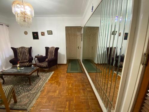 a living room with two chairs and a table and a chandelier at Mahitab music in Cairo