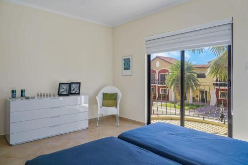 a bedroom with a bed and a dresser and a window at Splendid 3 bedroom house with beauttiful pool in Noord