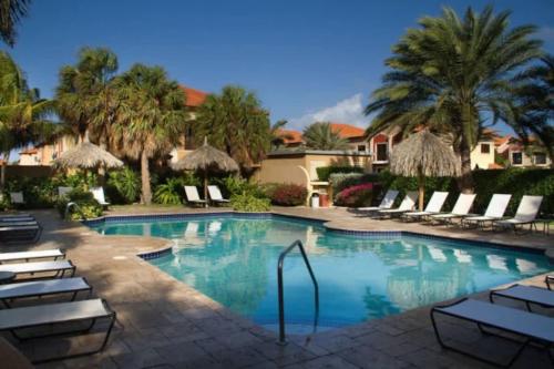 a large swimming pool with chairs and palm trees at Spectacular house in gold coast in Palm-Eagle Beach