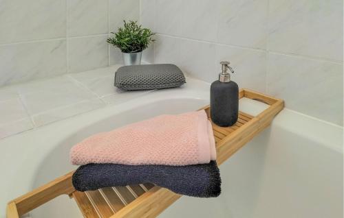 una bañera con una toalla y una botella. en Stunning Home In Vlagtwedde With Kitchen, en Vlagtwedde