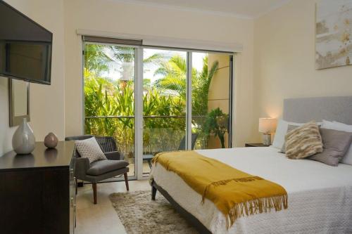 een slaapkamer met een bed, een bureau en een raam bij Modern apartment in levent in front of eagle beach in Palm-Eagle Beach