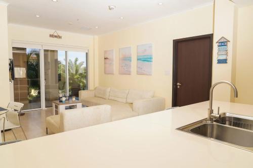 een keuken en een woonkamer met een bank en een wastafel bij Beautiful apartment in eagle beach levent in Palm-Eagle Beach