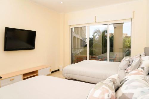 a living room with two beds and a flat screen tv at Beautiful apartment in eagle beach levent in Palm-Eagle Beach