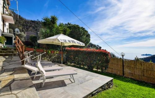 a patio with two chairs and an umbrella at Gorgeous Apartment In Zoagli With Wifi in Zoagli