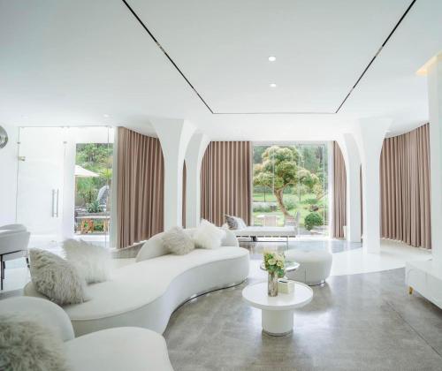 順化的住宿－Jade Hill Villa，客厅配有白色家具和大窗户