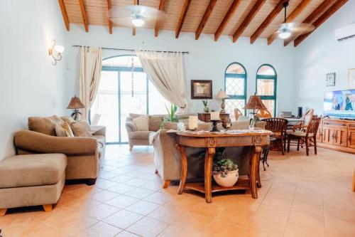 een grote woonkamer met een tafel en stoelen bij The elegance of Tierra del Sol with private pool in Palm-Eagle Beach