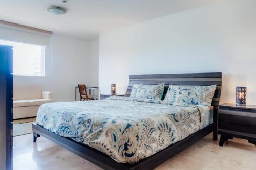 Un dormitorio con una cama con un edredón azul y blanco. en The Elegance of Oasis -3BR Apartment Beach Front, en Palm-Eagle Beach