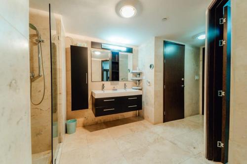 Un baño con lavabo, ducha y espejo. en The Elegance of Oasis -3BR Apartment Beach Front, en Palm-Eagle Beach
