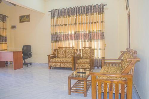 uma sala de estar com cadeiras, uma mesa e um piano em Yashora Gimanhala em Anuradhapura