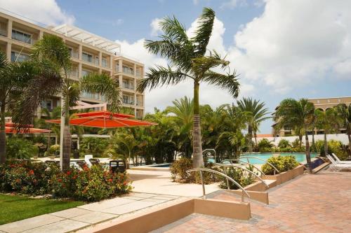 een resort met een palmboom en een zwembad bij Spectacular apartment in levent eagle beach in Palm-Eagle Beach