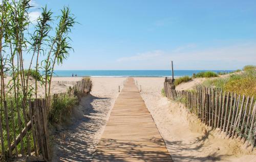 a wooden path to the beach with the ocean in the background at Lovely Home In Stlaurent-De-La-Cabr in Saint-Laurent-de-la-Cabrerisse