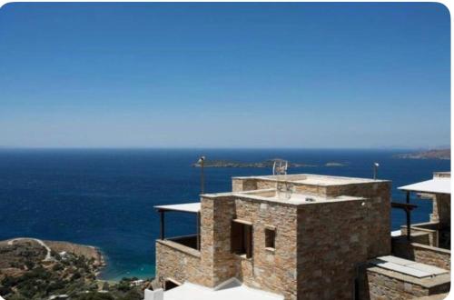 a stone building with the ocean in the background at Artemi in Andros