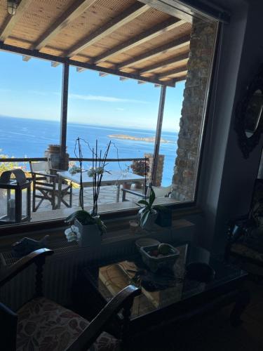 a room with a large window with a view of the ocean at Artemi in Andros
