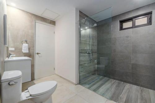 a bathroom with a toilet and a glass shower at Special studio apartment in gold coast in Noord