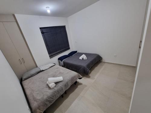 2 łóżka pojedyncze w pokoju z oknem w obiekcie Casa con alberca Mirador SD w mieście Querétaro