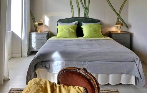 a bedroom with a bed with green pillows and a chair at La Recre Dempurany in Empurany