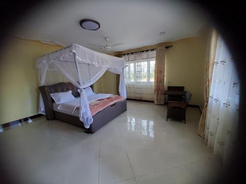 a bedroom with a bed with a canopy at Bigodi Community Lodge in Kamwenge