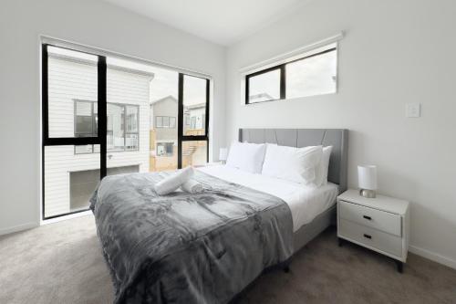 - une chambre avec un grand lit et une grande fenêtre dans l'établissement Cozy One-Bedroom Getaway in Takanini, à Auckland