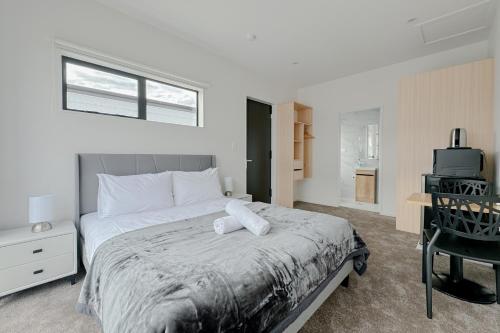 Dormitorio con cama, escritorio y TV en Cozy One-Bedroom Getaway in Takanini, en Auckland