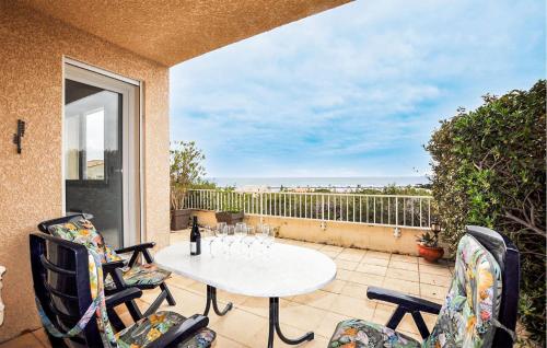 a patio with a table and chairs on a balcony at Stunning Home In Saint Pierre La Mer in Saint Pierre La Mer