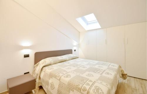 a white bedroom with a bed and a skylight at 2 Bedroom Amazing Apartment In Moneglia in Moneglia