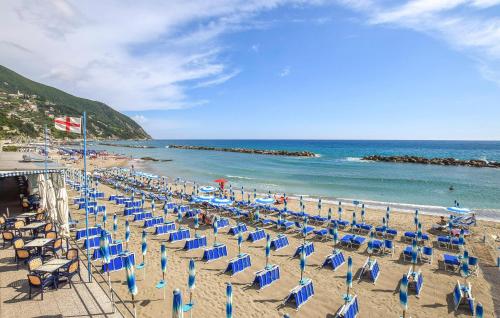 a beach with chairs and umbrellas and the ocean at 2 Bedroom Amazing Apartment In Moneglia in Moneglia