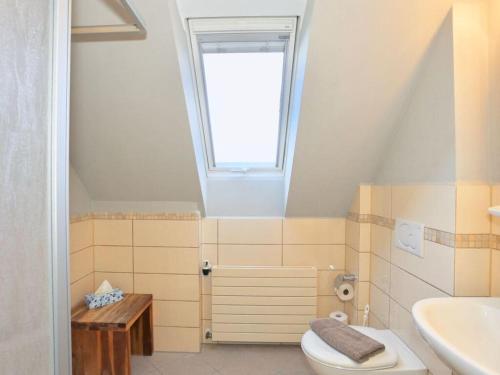 ein Bad mit einem WC, einem Waschbecken und einem Fenster in der Unterkunft Strandhuus Modern retreat in Juist