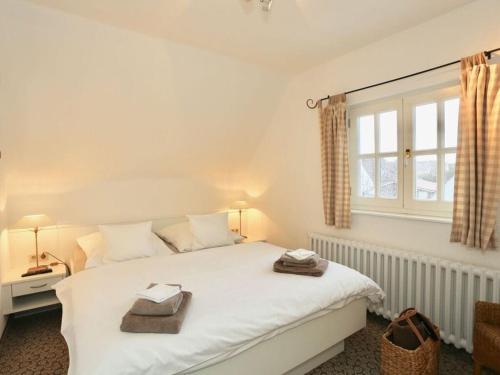 1 dormitorio con cama blanca y ventana en Strandhuus Modern retreat, en Juist