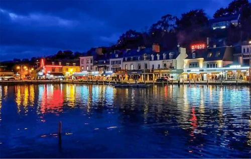 a city lit up at night with a body of water at Lovely Home In Pordic in Pordic