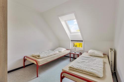 Duas camas num quarto com uma janela em Colibri 3 met parking em Nieuwpoort