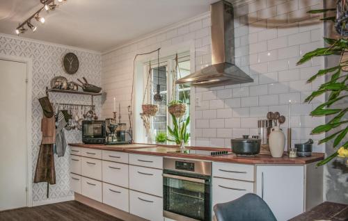 a kitchen with white cabinets and a stove top oven at 2 Bedroom Cozy Home In Halden in Halden