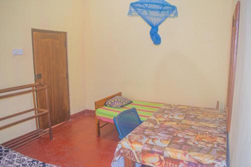 um quarto com uma cama e uma mesa com uma cadeira em Yashora Gimanhala em Anuradhapura
