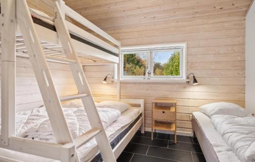 two bunk beds in a small room with a window at Nice Home In Glesborg With Wifi in Glesborg