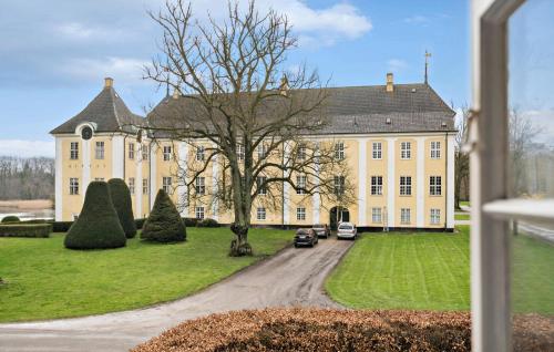 a large house with cars parked in front of it at 5 Bedroom Cozy Home In Næstved in Næstved