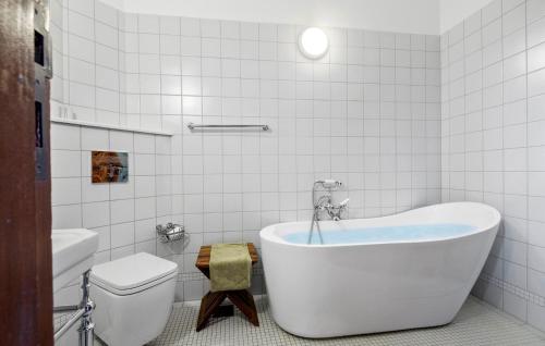 a white bathroom with a tub and a toilet at 5 Bedroom Cozy Home In Nstved in Næstved