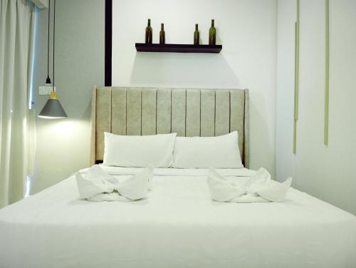 uma cama com lençóis brancos e duas almofadas em Summer Service Suite Klcc By CityBox em Kuala Lumpur