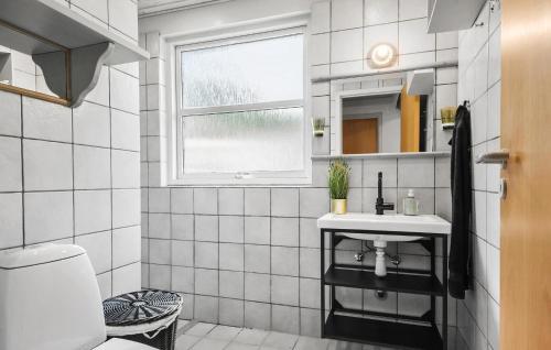 a white tiled bathroom with a sink and a window at Amazing Home In Ans By With Kitchen in Roe