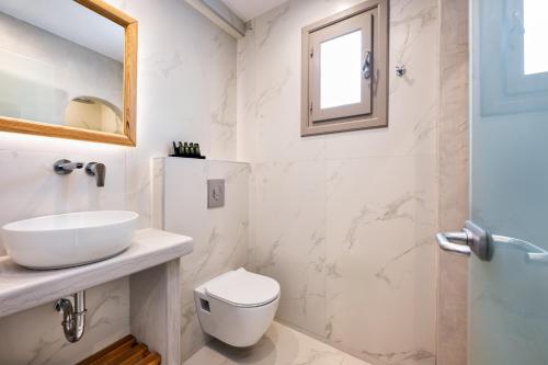 a bathroom with a sink and a toilet and a mirror at Villa Eleftheria in Perivolos
