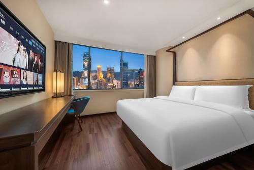 ein Hotelzimmer mit einem großen Bett und einem großen Fenster in der Unterkunft SSAW Hotel Chongqing Great World Jiefangbei in Chongqing