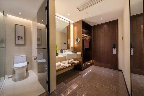 a bathroom with a toilet and a sink and a mirror at SSAW Hotel Chongqing Great World Jiefangbei in Chongqing