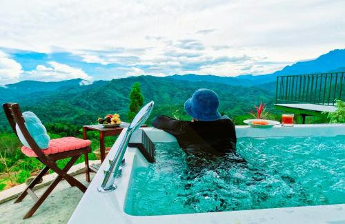 a person sitting in a swimming pool with skis at Hawun Valley Kiulu in Tamparuli