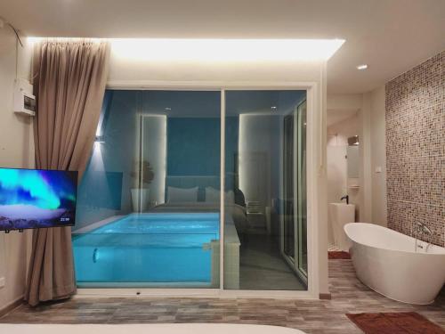 a bathroom with a bath tub and a tub and a bath tub at Skyline Resort in Ban Khlong Lat Bua Khao