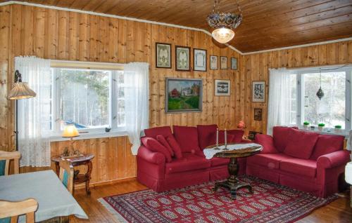 OsにあるGorgeous Home In Os I Østerdalenの赤い家具と木製の壁が備わるリビングルーム