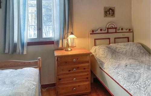 a bedroom with a bed and a dresser with a lamp at Cozy Home In Os I sterdalen With Kitchen in Os