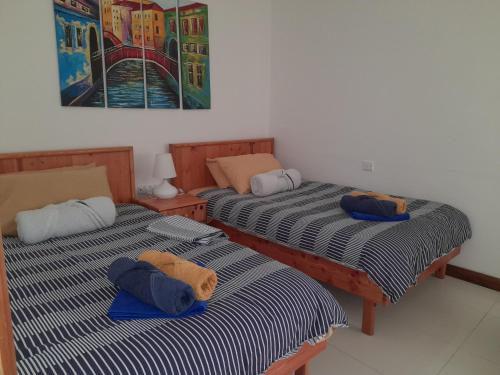 MġarrにあるEast Breeze Penthouseのベッド2台が隣同士に設置された部屋です。